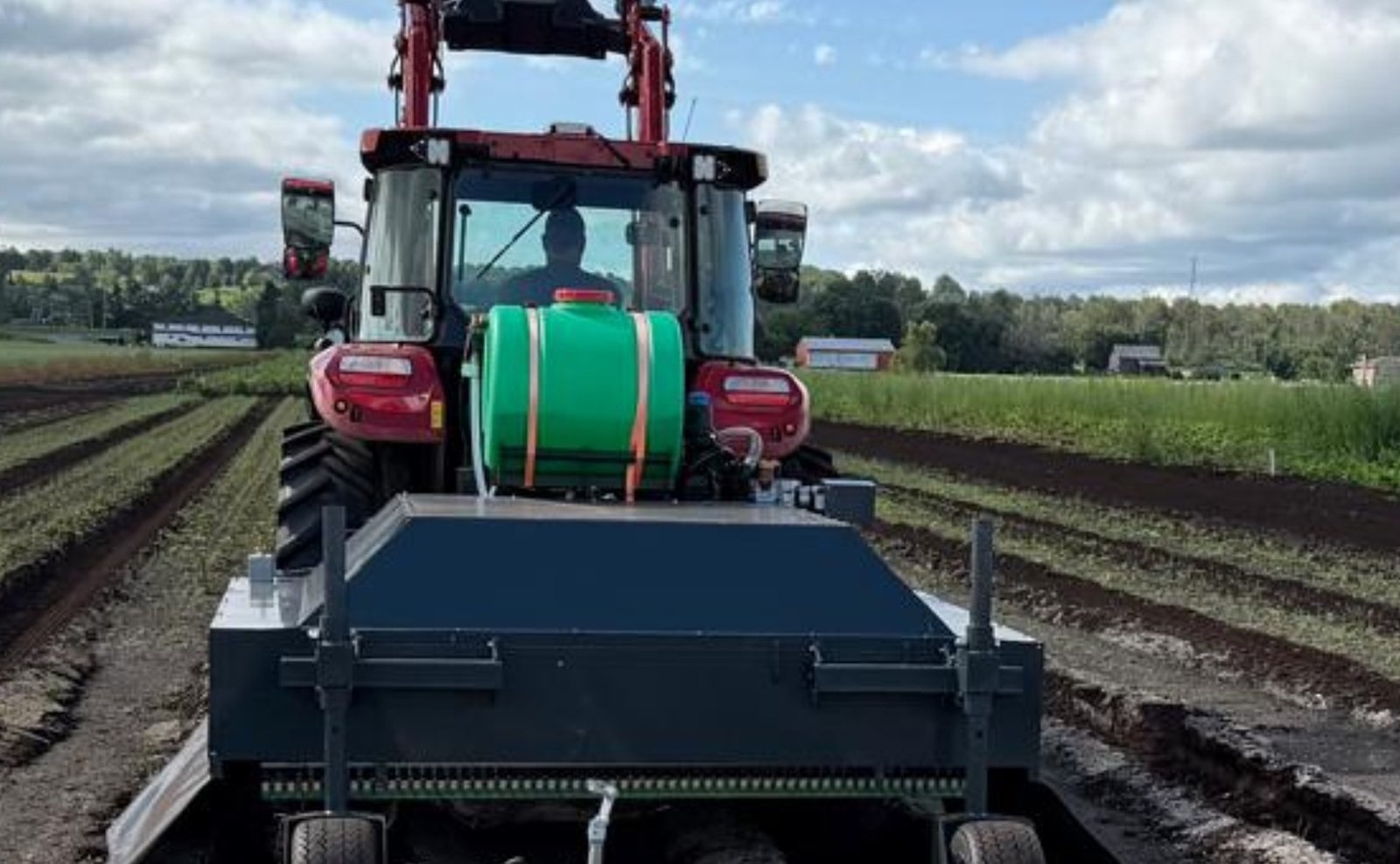 BearClaw Archer precision spray unit towed behind a tractor in a row-crop field